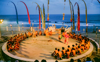 Kecak and Fire Dance performance at Melasti Beach with ocean backdrop.