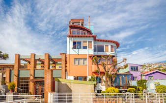 Colorful house in Valparaíso, Chile, with vibrant architecture and surrounding hillside homes.
