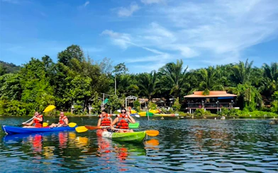 Kayakers paddling on a river surrounded by lush greenery in Krabi.