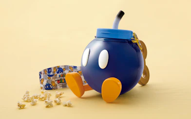 Super Nintendo World popcorn bucket shaped like a character with scattered popcorn.