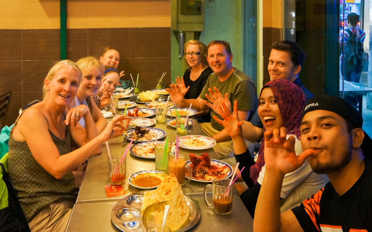 Street food vendor preparing traditional Malaysian dishes in Kuala Lumpur during the Flavours of Malaysia Food Tour.