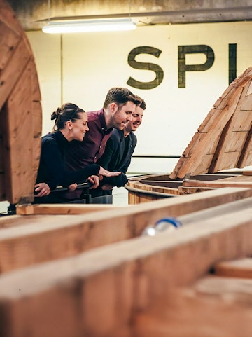Visitors observing whiskey barrels at Teeling Whiskey Distillery, Dublin.