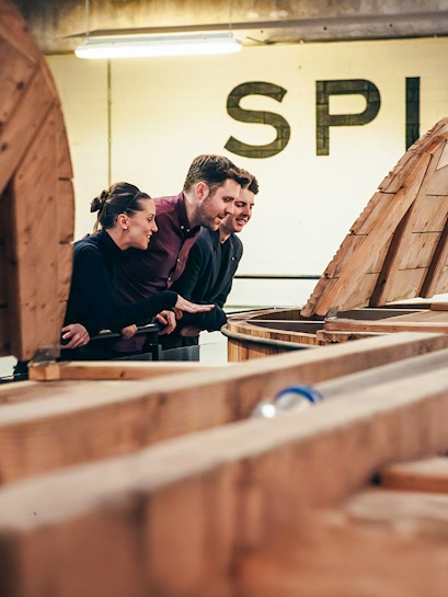 Visitors observing whiskey barrels at Teeling Whiskey Distillery, Dublin.