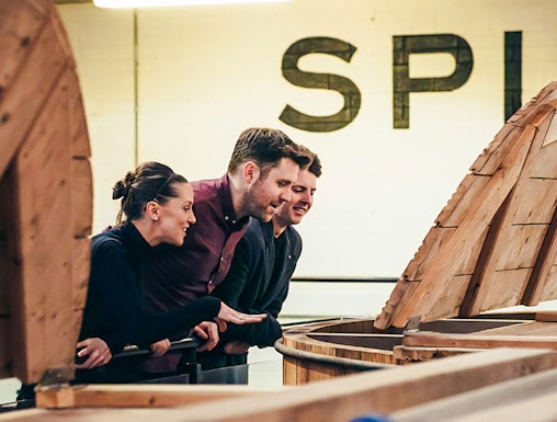 Visitors observing whiskey barrels at Teeling Whiskey Distillery, Dublin.
