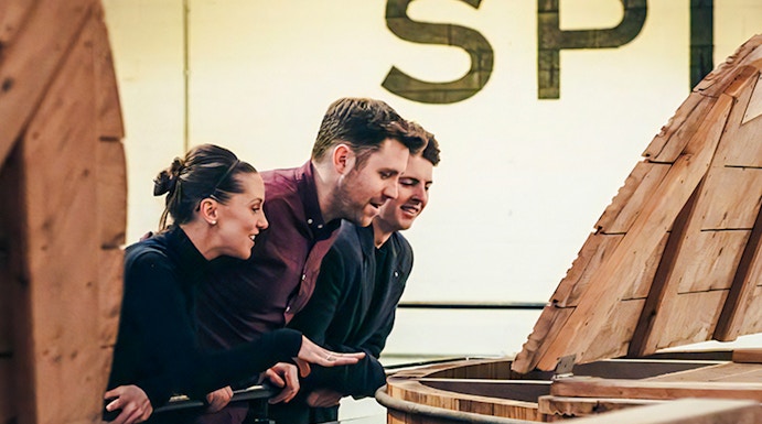 Visitors observing whiskey barrels at Teeling Whiskey Distillery, Dublin.