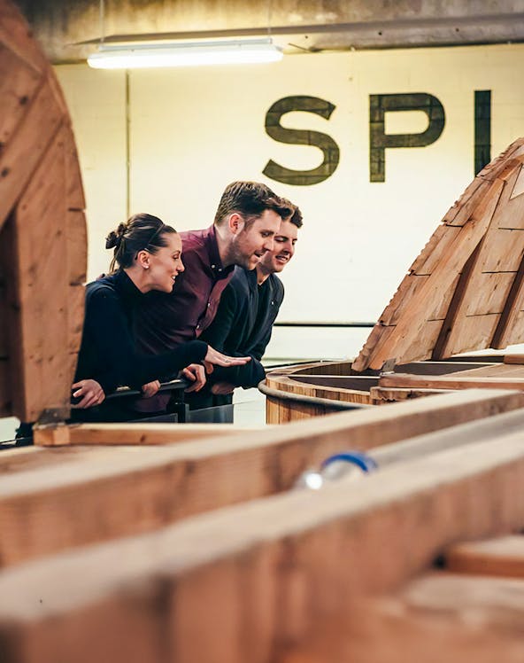 Visitors observing whiskey barrels at Teeling Whiskey Distillery, Dublin.