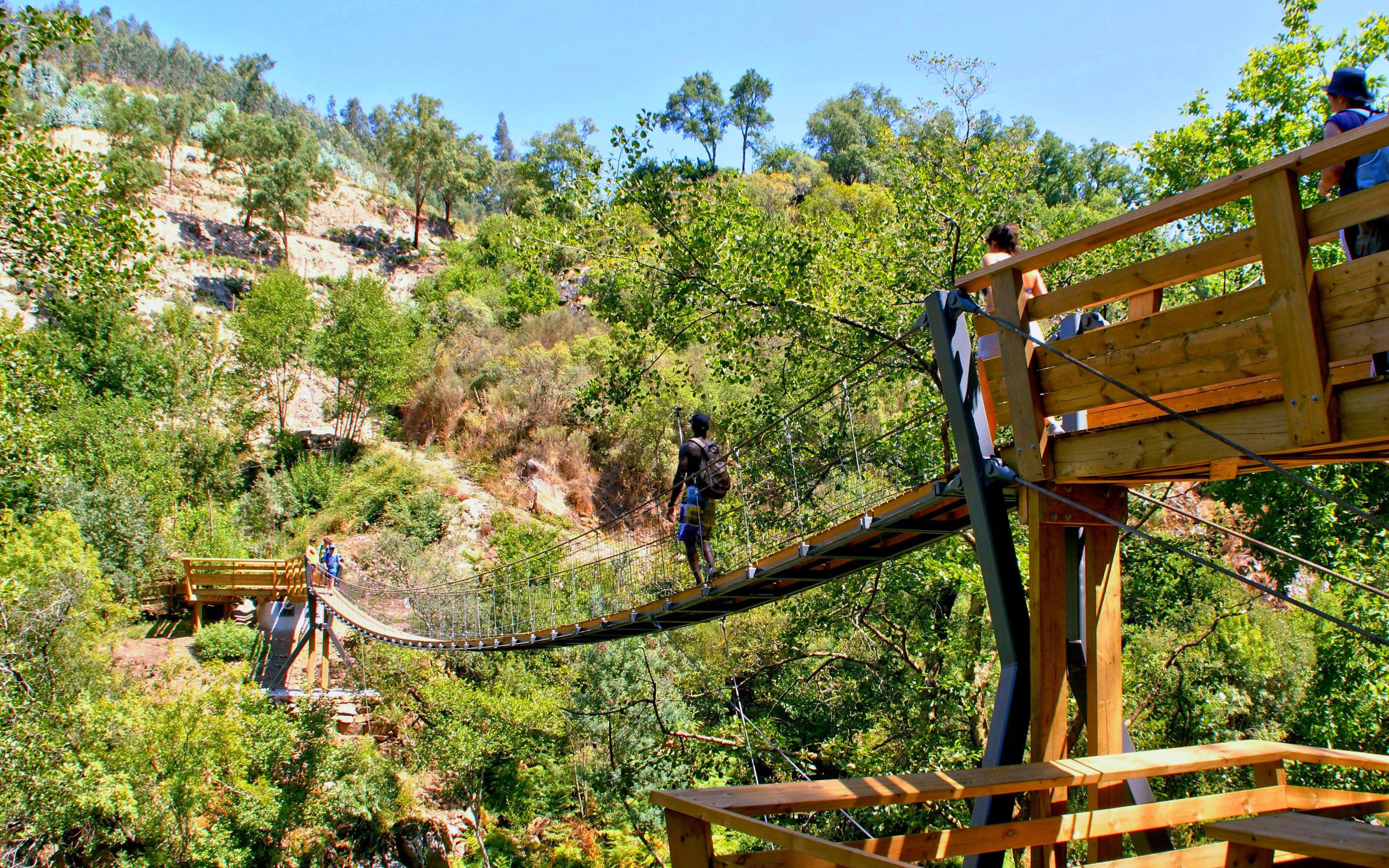 Visitors crossing a suspension bridge on the Paiva Walkways in Arouca, Portugal.