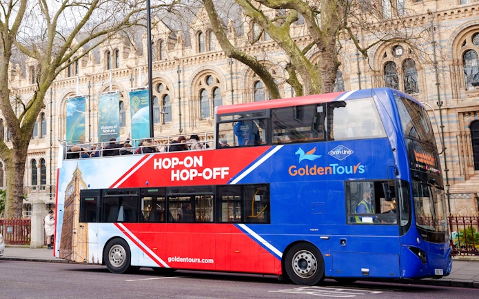 Golden Tours hop-on hop-off bus in front of a historic building in London.