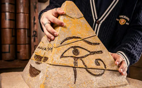 Pyramid puzzle piece with Eye of Horus in Curse of the Pharaoh Escape Room, Dubai.
