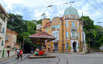 Yellow tram stop and historic building in Santa Teresa, Rio de Janeiro.