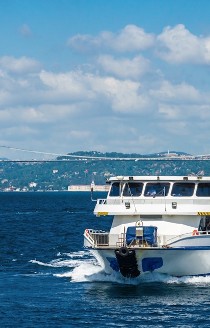 Bosphorus cruise ship sailing near a bridge in Istanbul, Turkey.