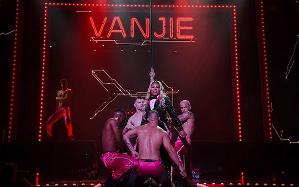 Performer on stage at RuPaul's Drag Race LIVE! Vegas show with dancers.