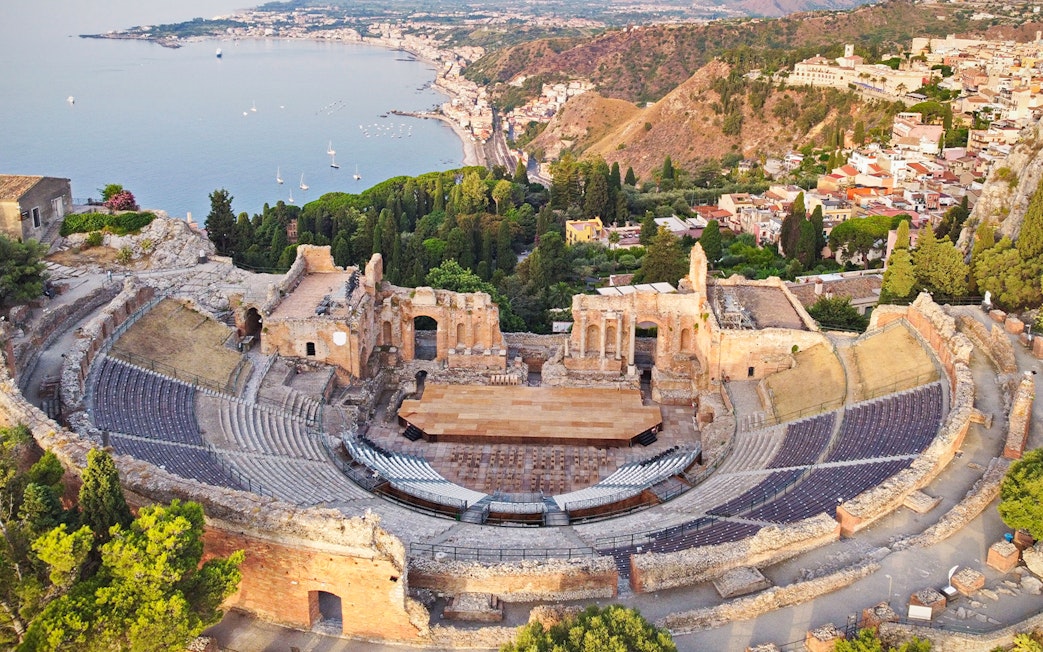 Aerial view of Taormina Ancient Theatre with coastal landscape in Sicily.