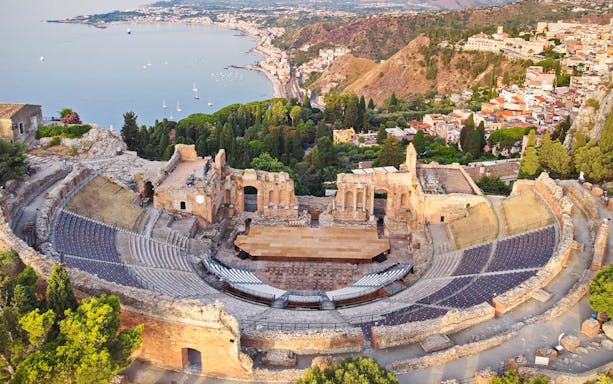 Aerial view of Taormina Ancient Theatre with coastal landscape in Sicily.