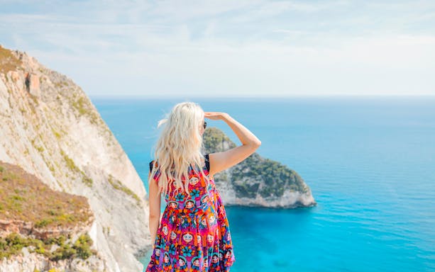 Guests enjoying the view from Navagio Viewpoint, Zakynthos, overlooking cliffs and sea.