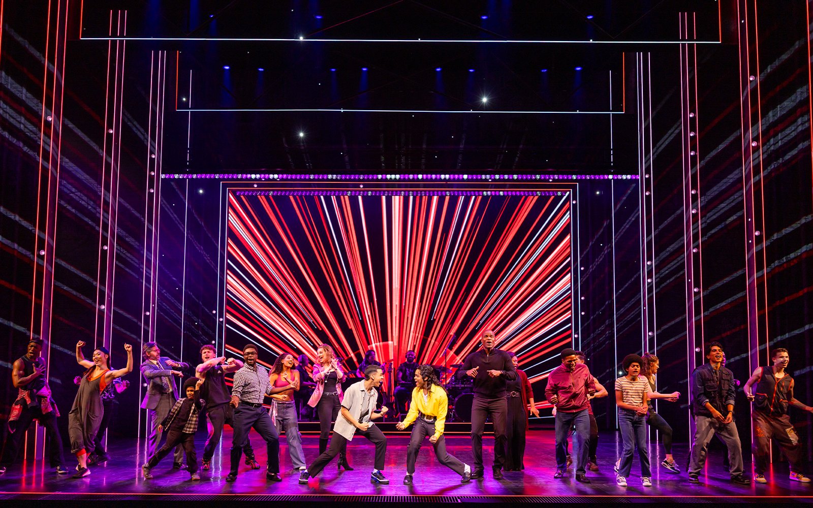 Stage performance of MJ the Musical in Brisbane with dancers in front of vibrant red lights.