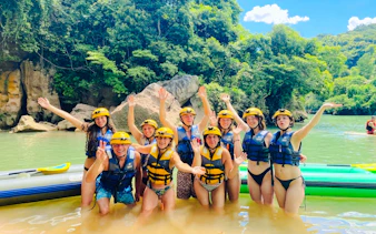 Group enjoying water activities with helmets and life vests in Phong Nha, Vietnam.