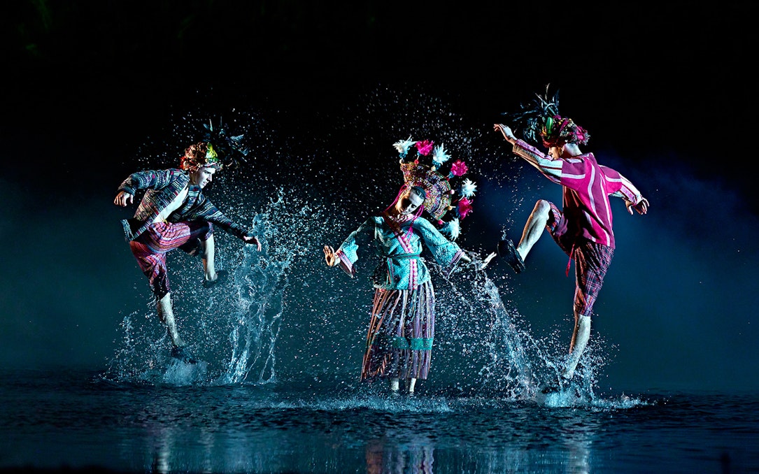 Performers in traditional costumes dance through water in "The Dream of Toledo" show.