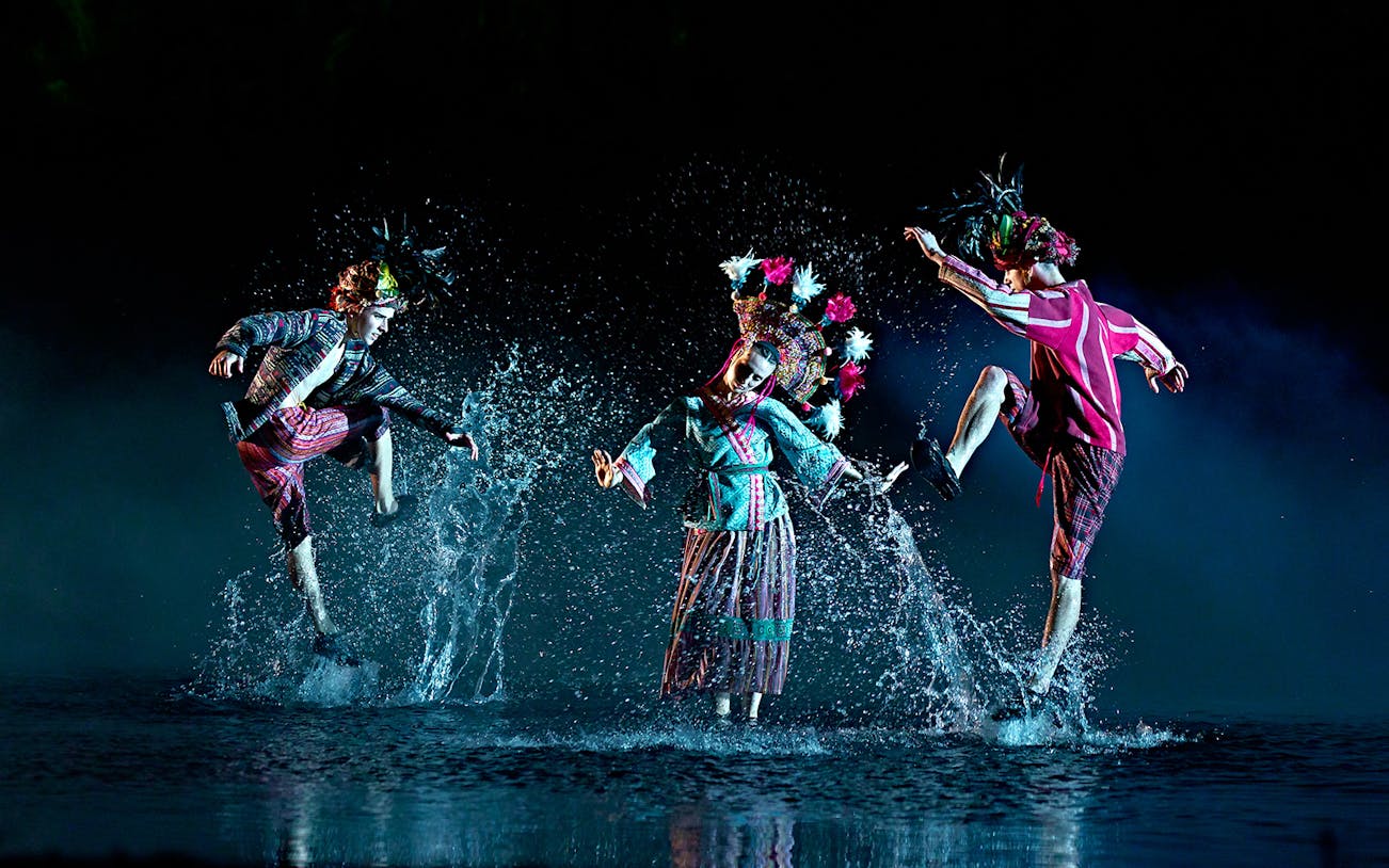 Performers in traditional costumes dance through water in "The Dream of Toledo" show.