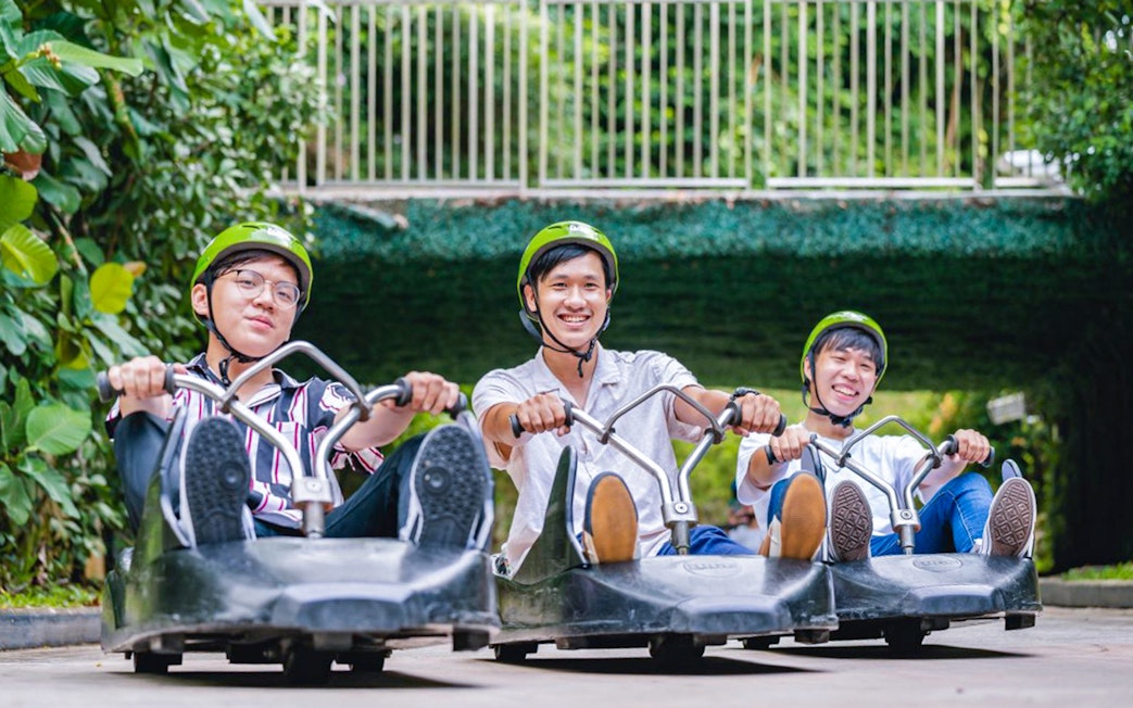 Three people enjoying the Skyline Luge ride in Singapore.