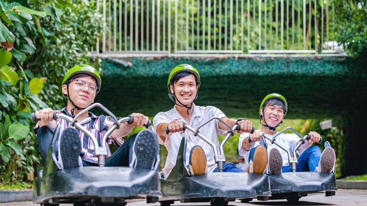 Three people enjoying the Skyline Luge ride in Singapore.