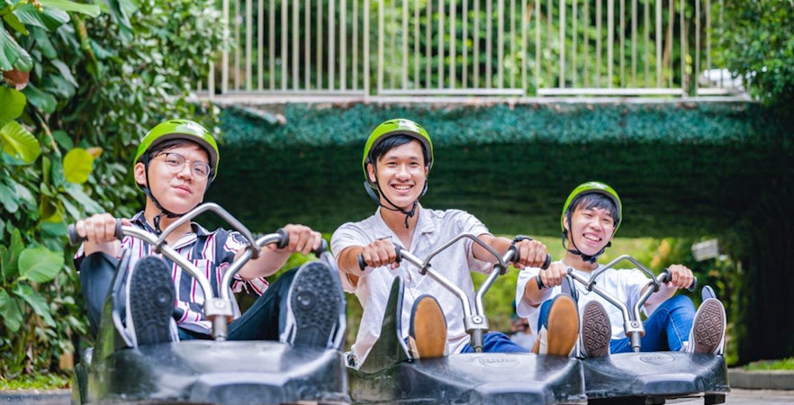 Three people enjoying the Skyline Luge ride in Singapore.