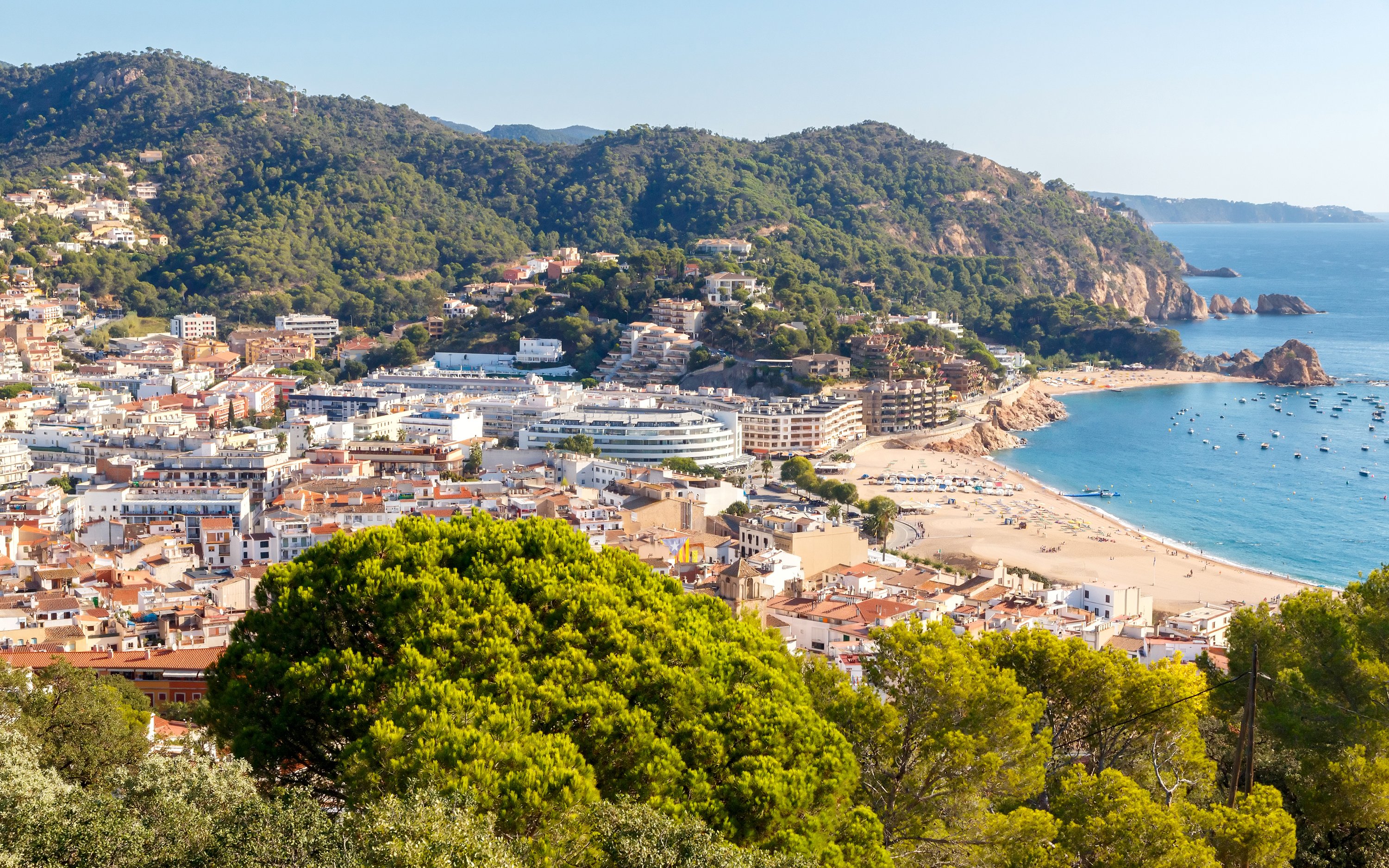 Coastal view of Tossa de Mar on the Costa Brava, Catalonia, Spain, with beach and town buildings.