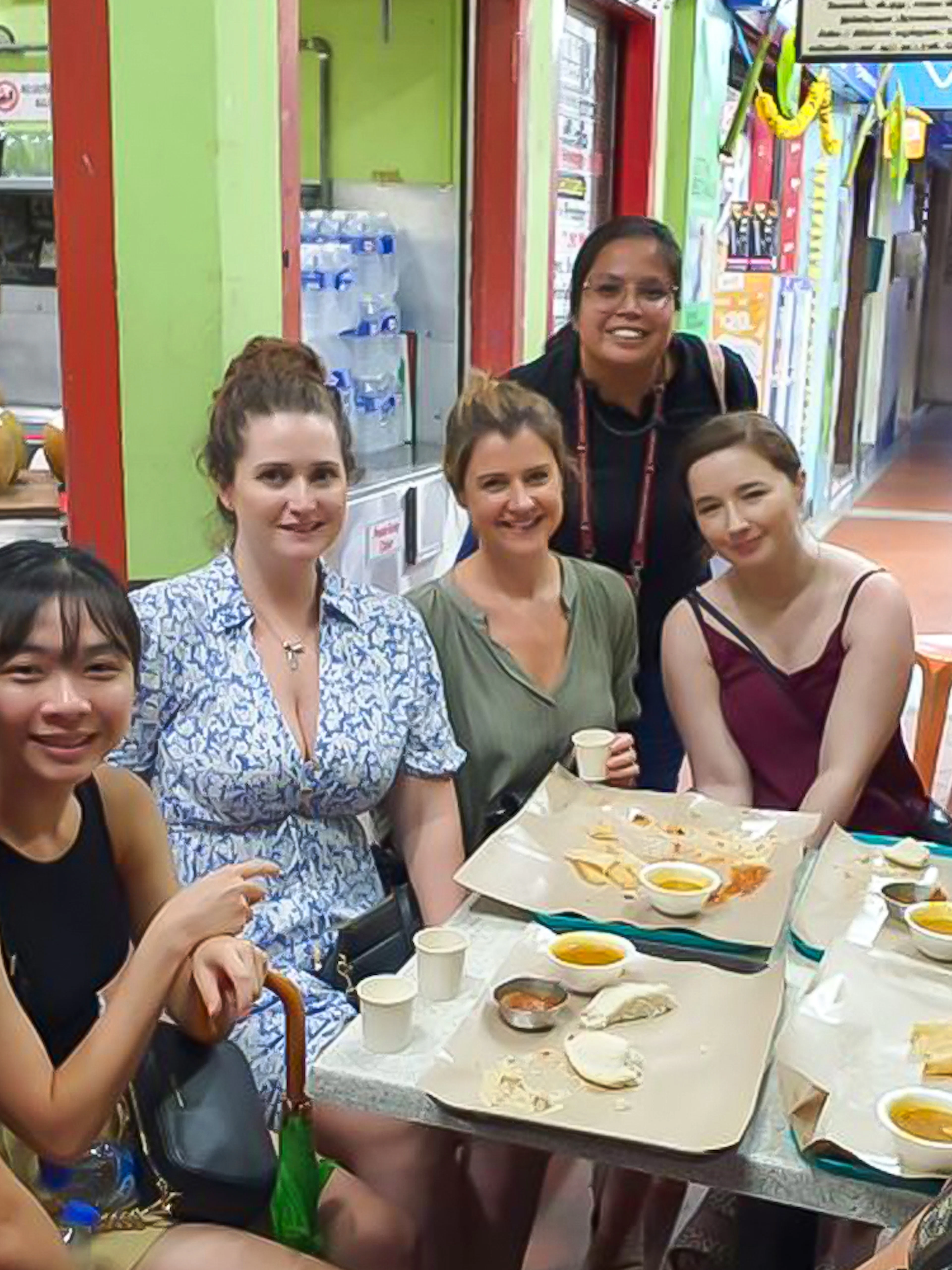 Group enjoying food at a table on a guided tasting tour in Little India Hawker Street, Singapore.