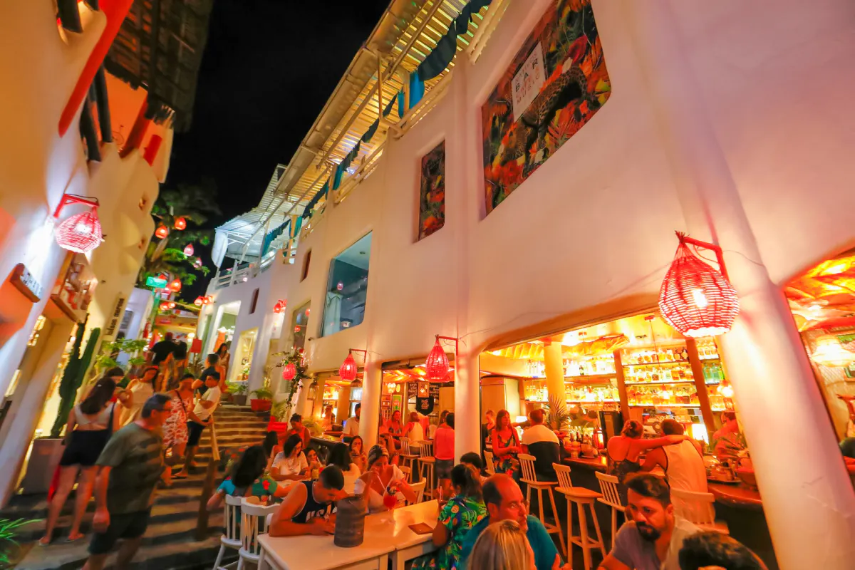 Outdoor dining and nightlife scene in Pipa Village, Sao Paulo, with people enjoying a vibrant evening.