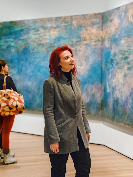 Visitors admiring Monet's Water Lilies at a museum exhibit.