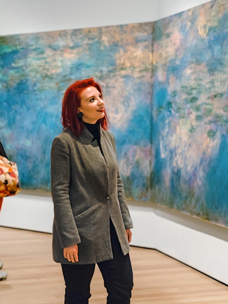 Visitors admiring Monet's Water Lilies at a museum exhibit.