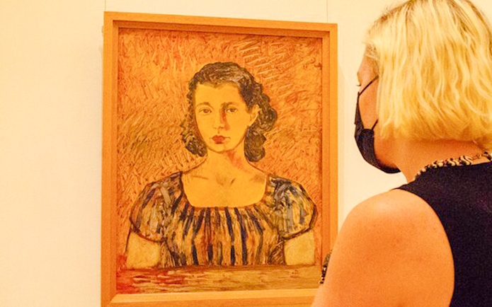 Visitor viewing a portrait at the Frida Kahlo Museum in Mexico City.