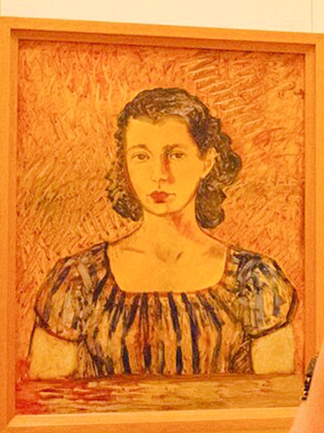 Visitor viewing a portrait at the Frida Kahlo Museum in Mexico City.