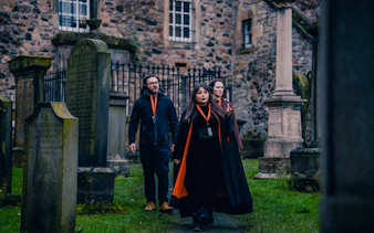 Tour guide leading guests through a historic graveyard in Edinburgh.
