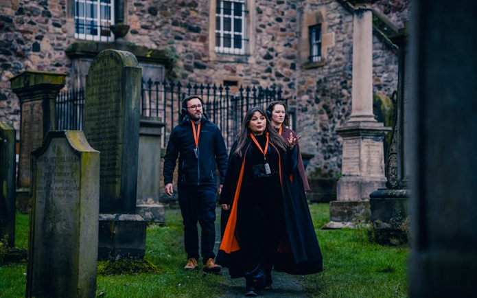 Tour guide leading guests through a historic graveyard in Edinburgh.