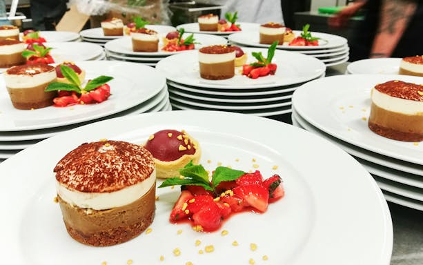 Dessert plates with chocolate mousse and strawberries for afternoon tea event.