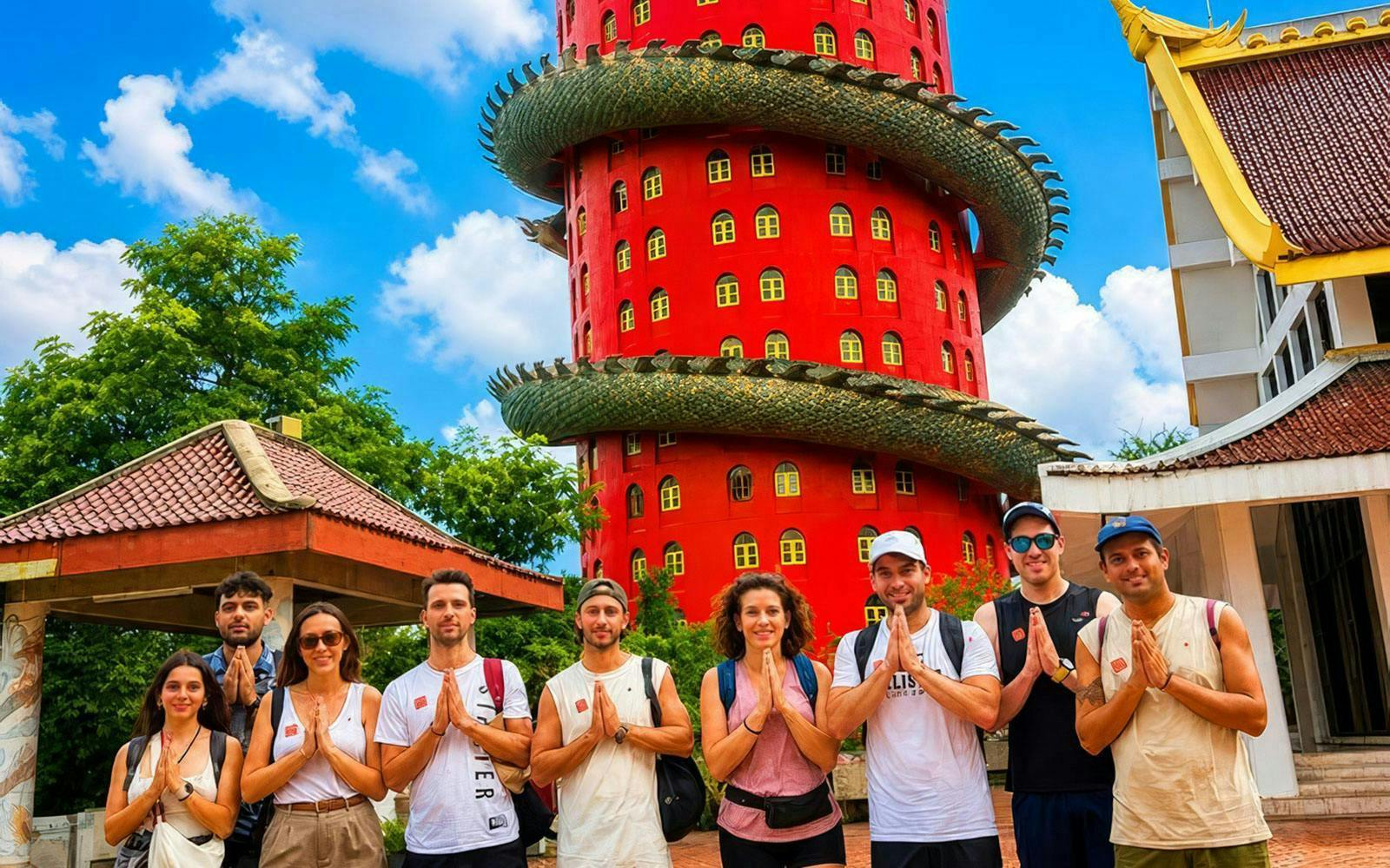 Tourists posing in front of the red Dragon Temple in Thailand.