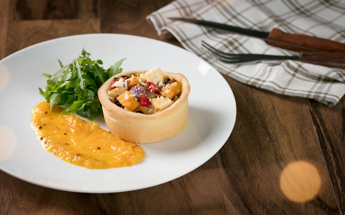Australian Outback Spectacular dinner featuring a savory tart with salad and sauce.