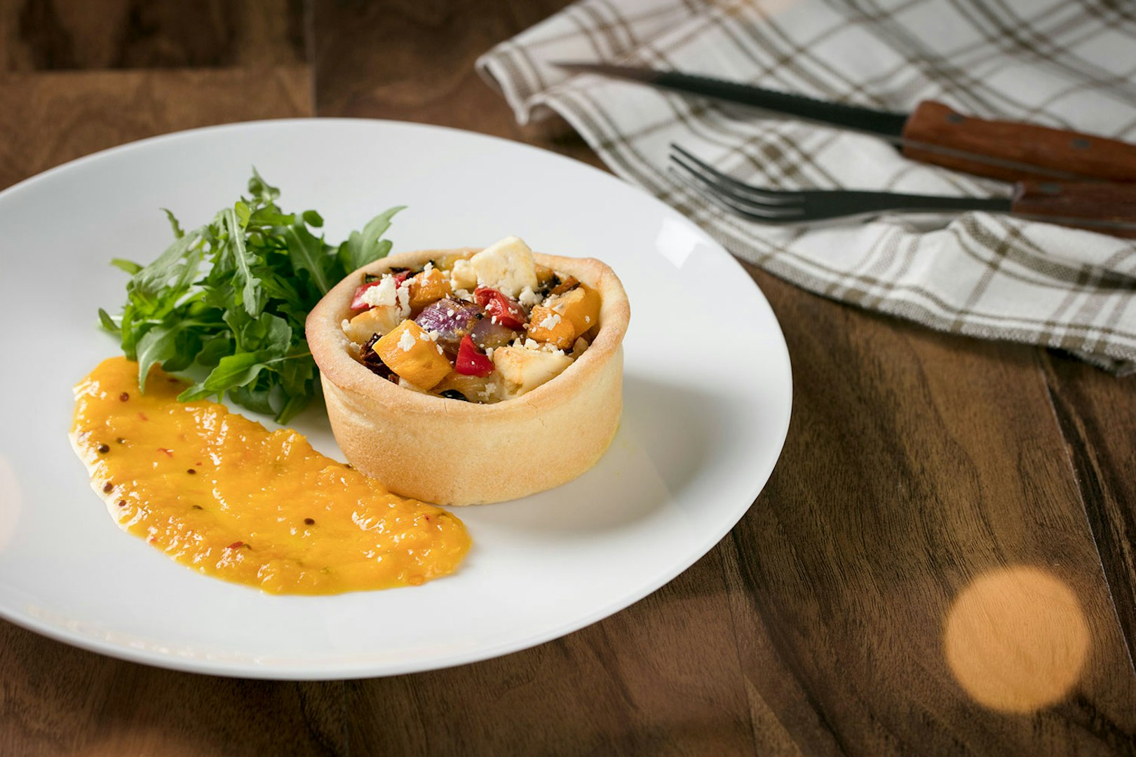 Australian Outback Spectacular dinner featuring a savory tart with salad and sauce.