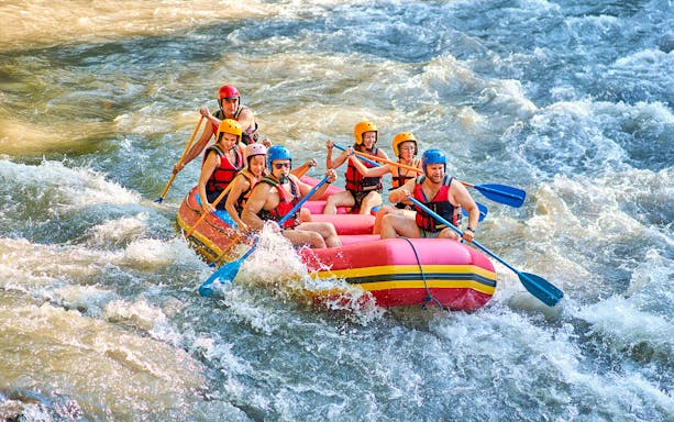 White water rafting group navigating rapids in Bali.