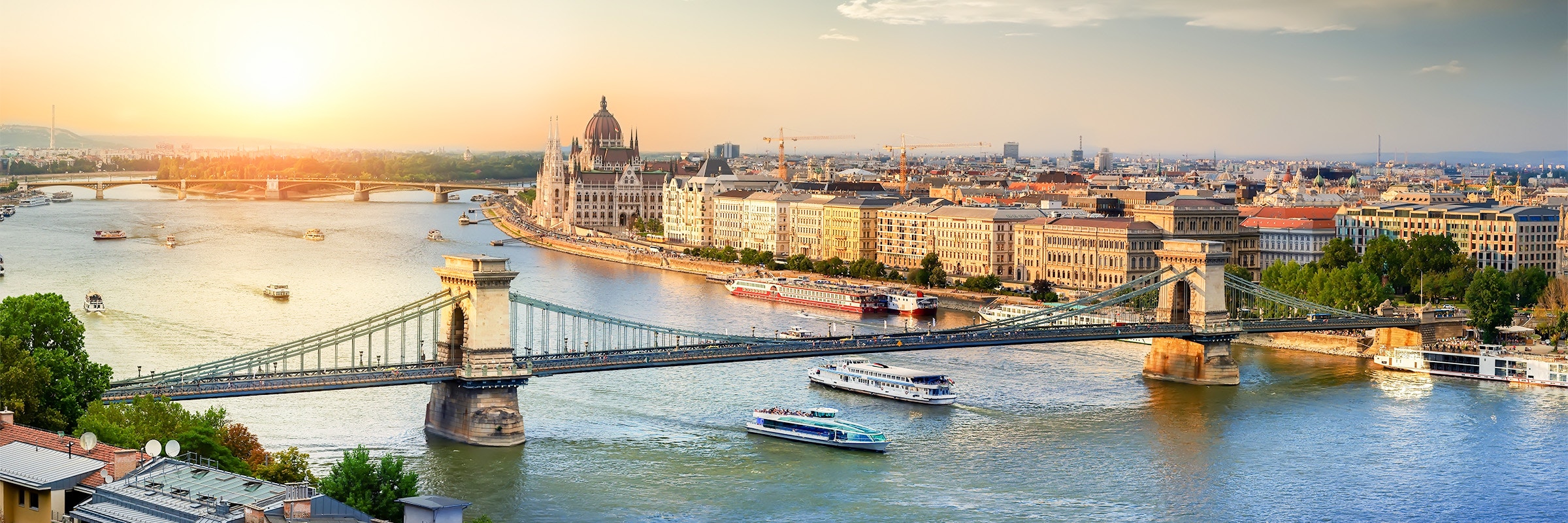 Parliament building along the Danube River in Budapest during sunset.