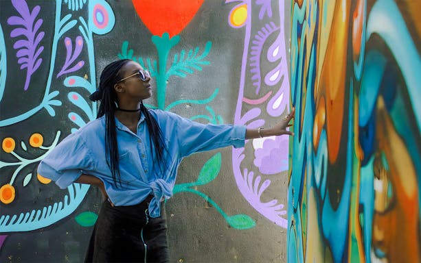 Person exploring vibrant street art mural during guided tour in Lisbon.