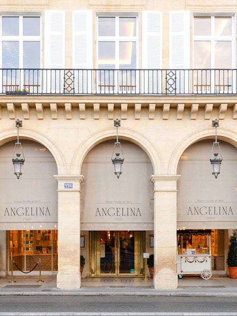Entrance of Angelina Rivoli café with arched windows in Paris, France.