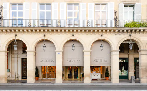 Entrance of Angelina Rivoli café with arched windows in Paris, France.