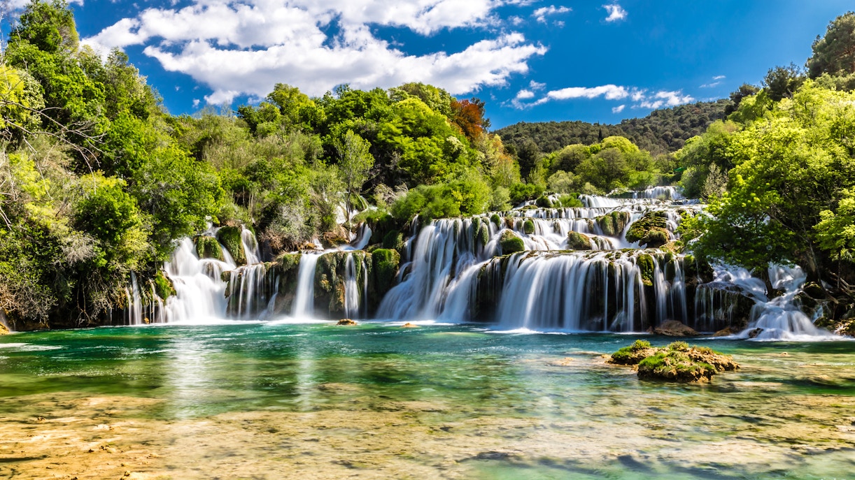 Plitvice Waterfalls cascading over lush greenery in Croatia.