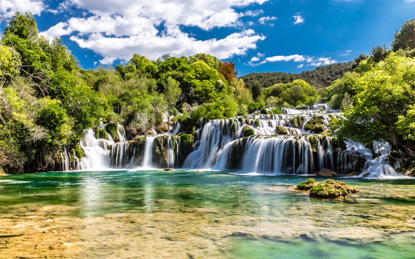 Plitvice Waterfalls cascading over lush greenery in Croatia.