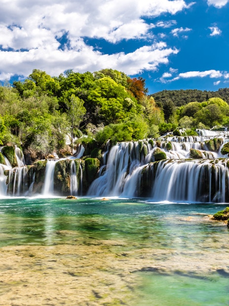 Plitvice Waterfalls cascading over lush greenery in Croatia.
