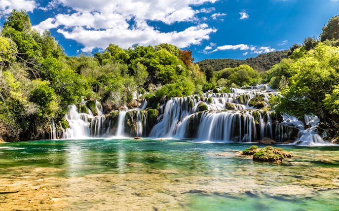 Plitvice Waterfalls cascading over lush greenery in Croatia.