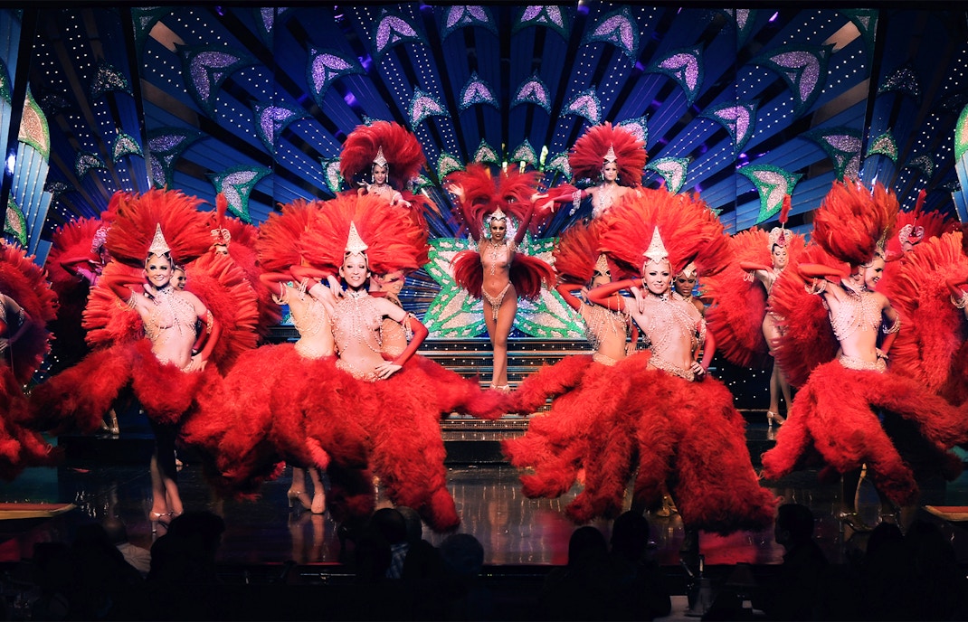 Guests watching a vibrant show at the Moulin Rouge in Paris.