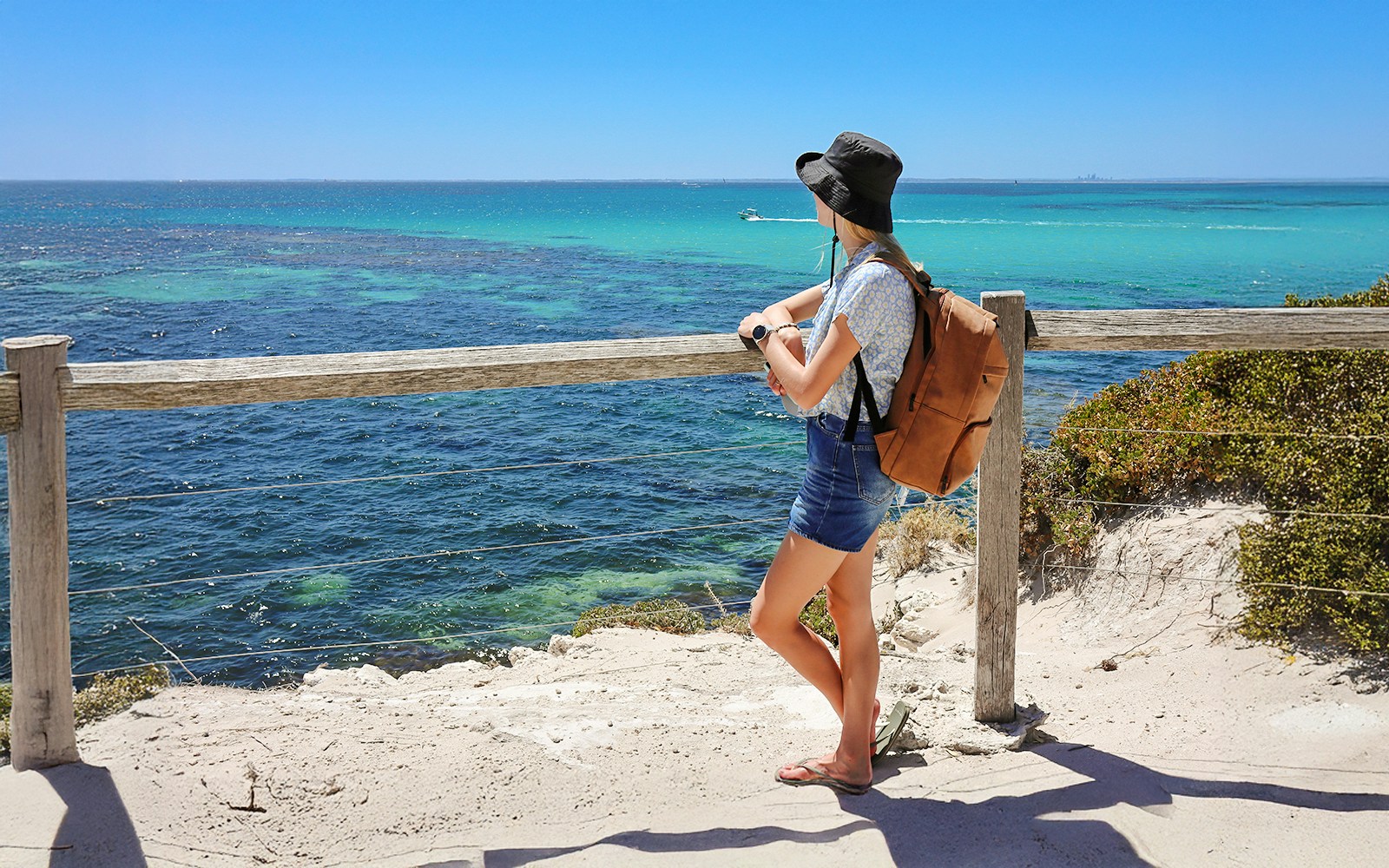 Woman enjoying ocean view from Rottnest Island lookout.